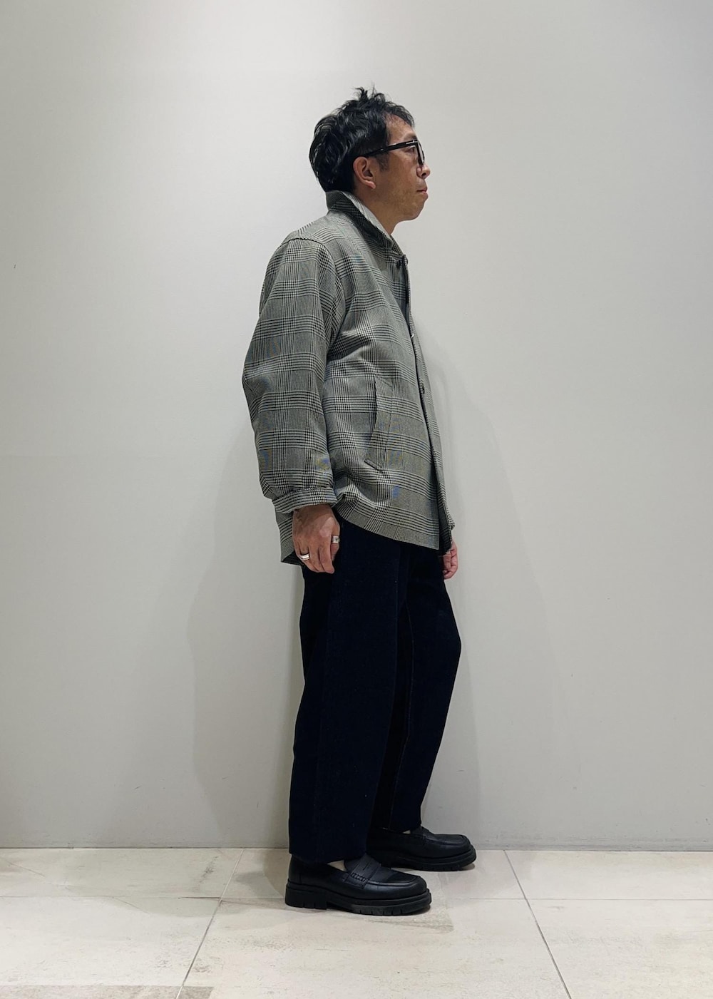 ブラック系のローファー、ブルー系のデニムパンツ、ブラック系のニット/セーターを着用したメンズの冬コーディネートの4枚目の写真