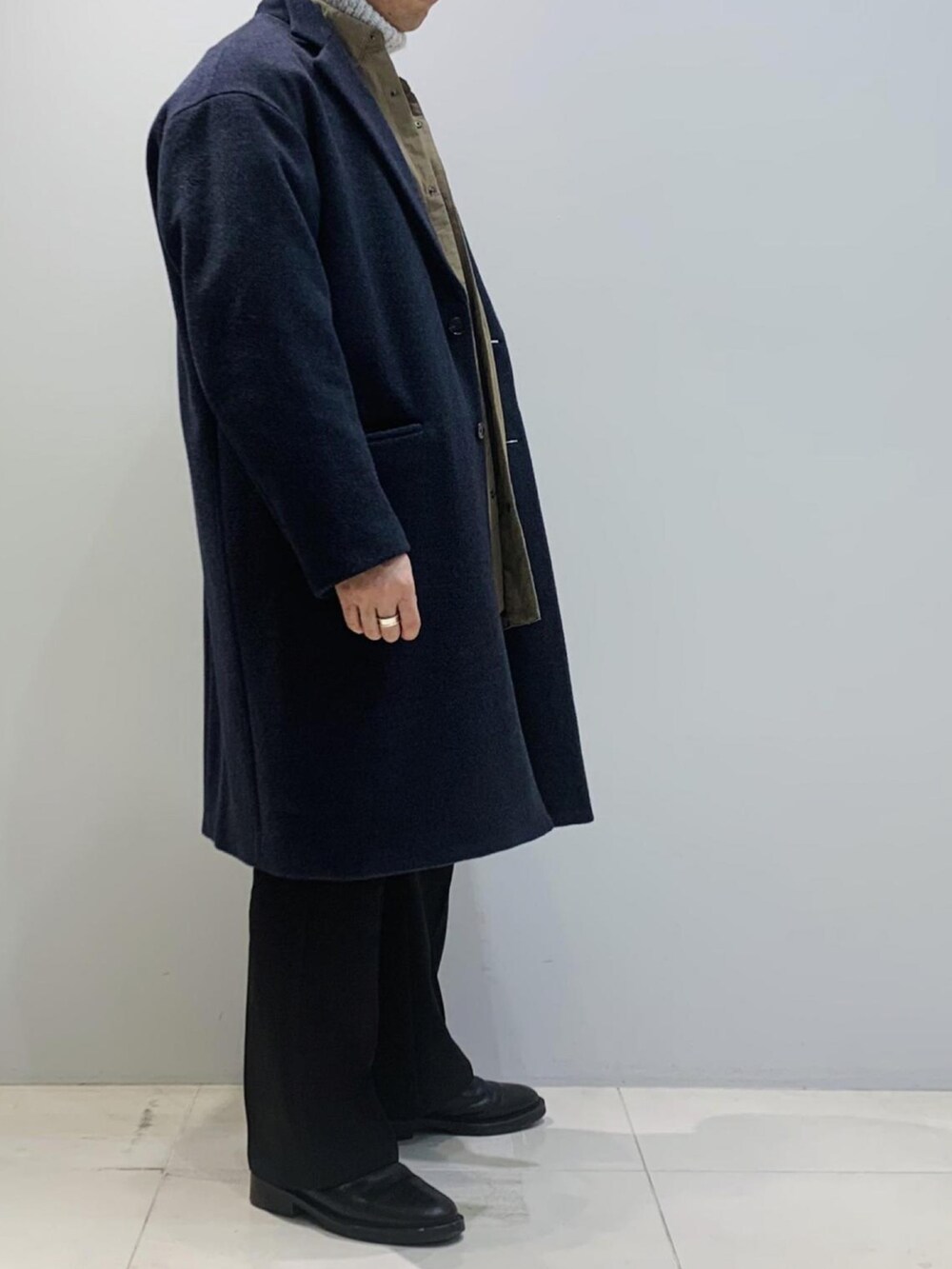 ブラック系のブーツ、ブラック系のその他パンツ、ブルー系のチェスターコートを着用したメンズの冬コーディネートの2枚目の写真