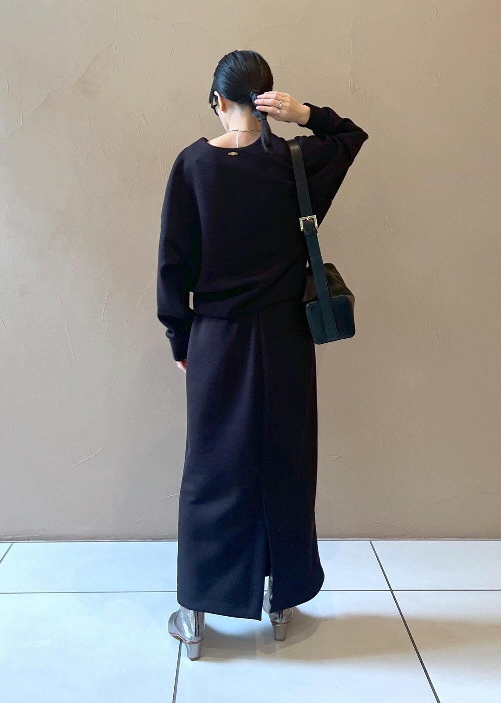 ブラック系のショルダーバッグ、ブラック系のスカート、ブラック系のTシャツ/カットソーを着用したレディースの秋コーディネートの3枚目の写真