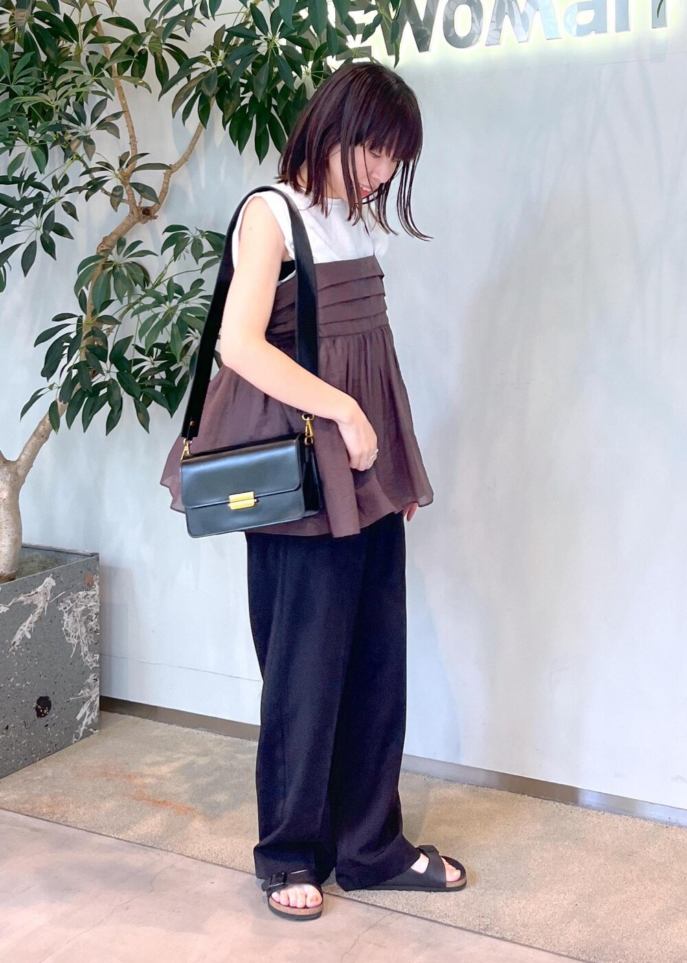 ホワイト系のTシャツ/カットソー、ブラウン系のキャミソール、ブラック系のショルダーバッグを着用したレディースの夏コーディネートの3枚目の写真