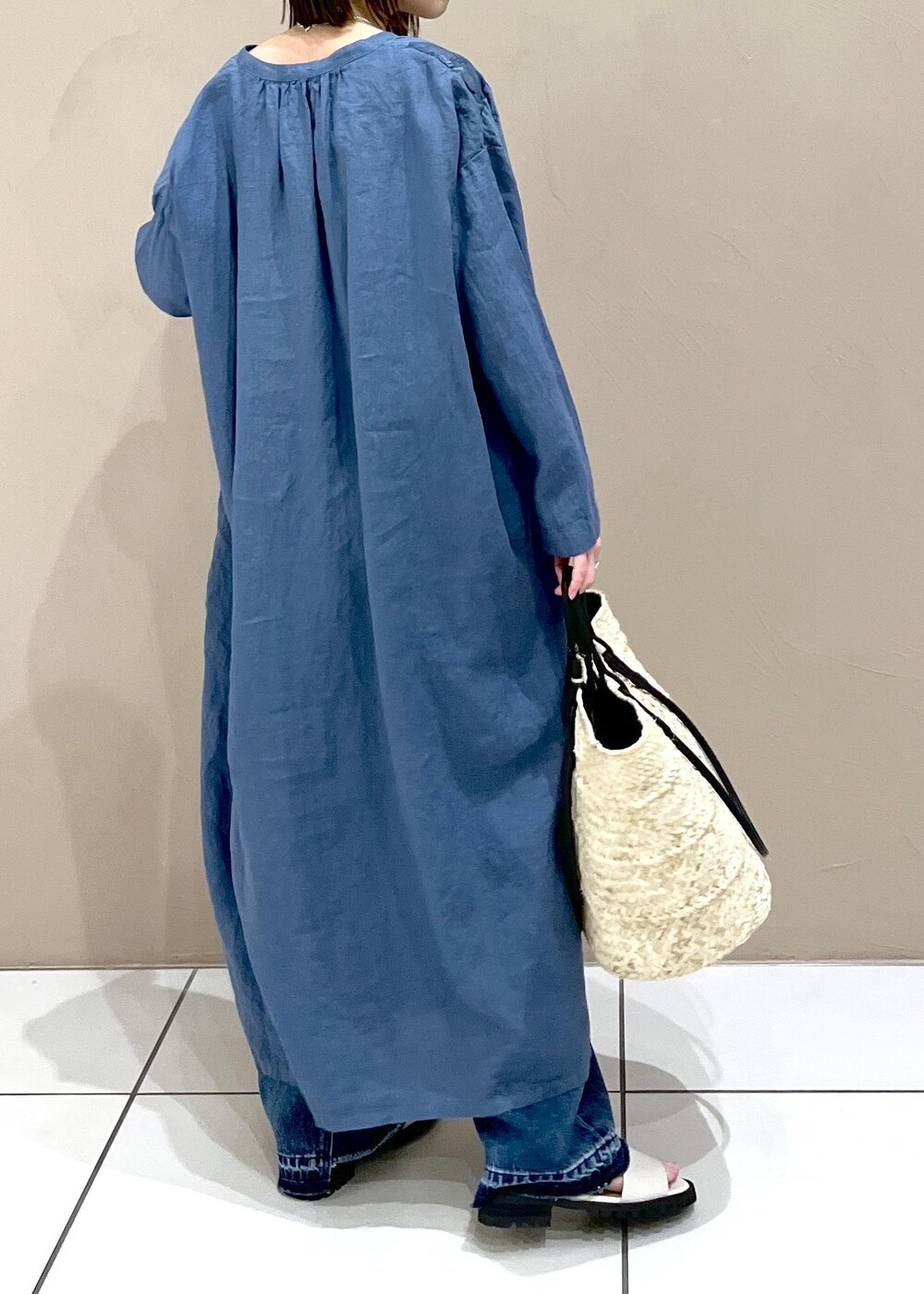 ブルー系のデニムパンツ、ホワイト系のかごバッグを着用したレディースの春コーディネートの3枚目の写真