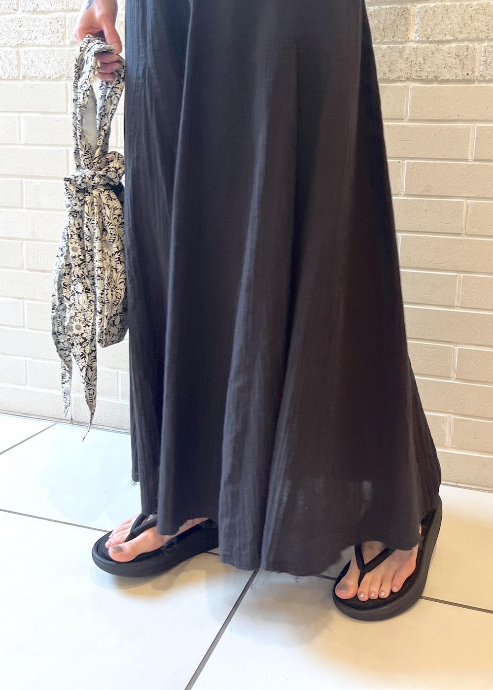 グリーン系のTシャツ/カットソー、ブラック系のスカート、ブラック系のトートバッグを着用したレディースの春コーディネートの5枚目の写真