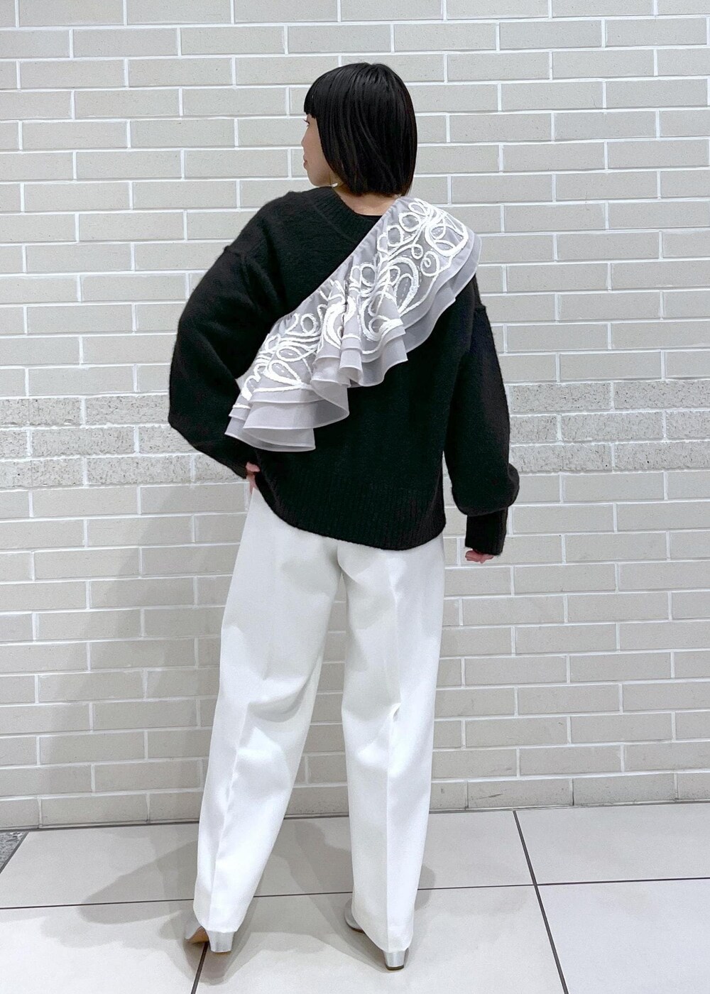 ブラウン系のニット/セーター、ホワイト系のその他パンツ、ベージュ系のストール/ショールを着用したレディースの冬コーディネートの2枚目の写真