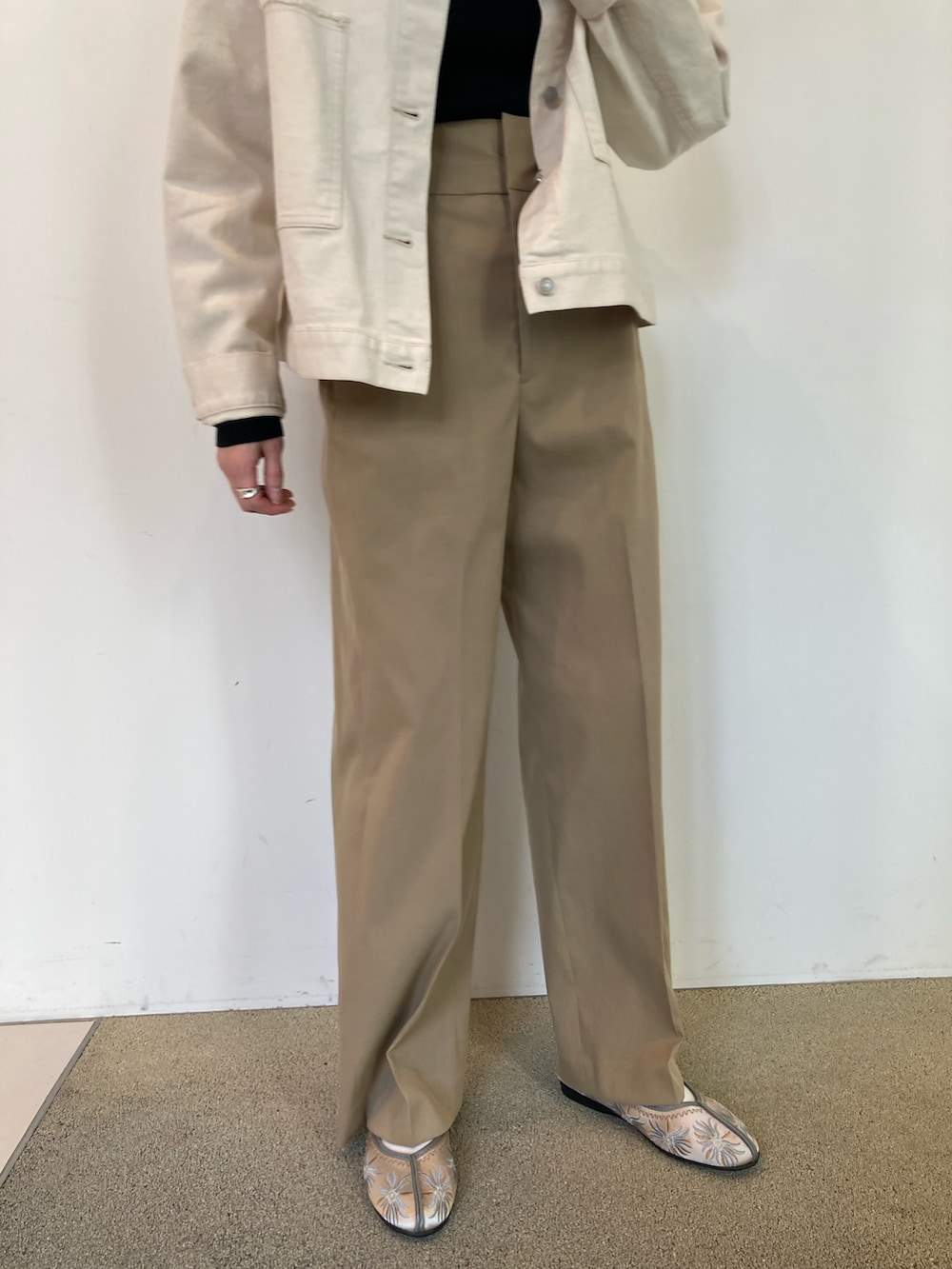 ブラック系のニット/セーター、ホワイト系のブルゾン、ベージュ系のその他パンツを着用したレディースの春コーディネートの5枚目の写真