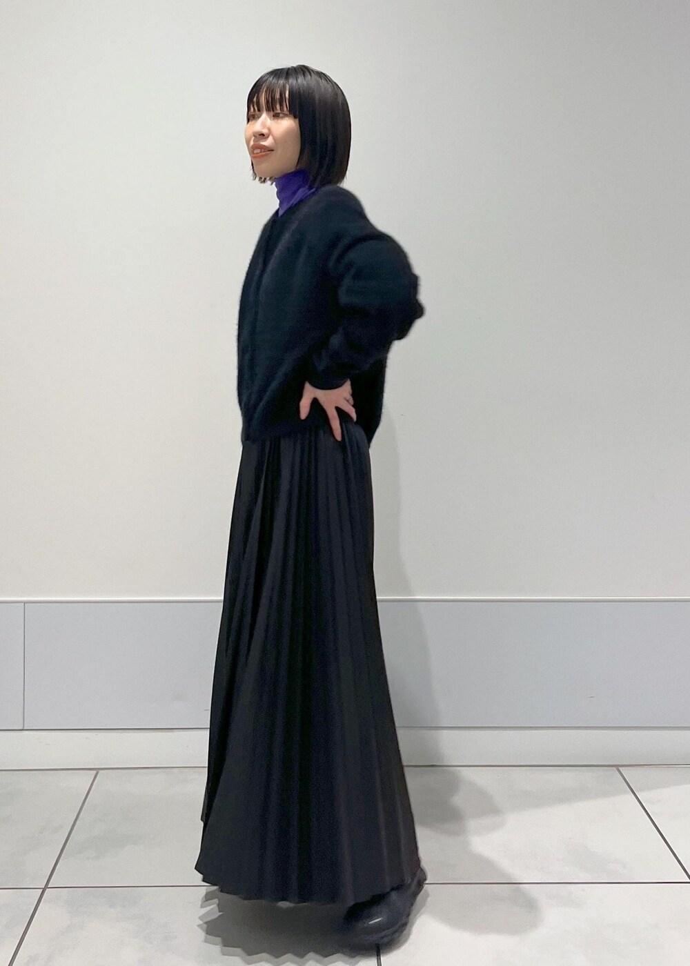 ブラック系のショルダーバッグ、ブラック系のカーディガン/ボレロ、パープル系のTシャツ/カットソーを着用したレディースの秋コーディネートの2枚目の写真