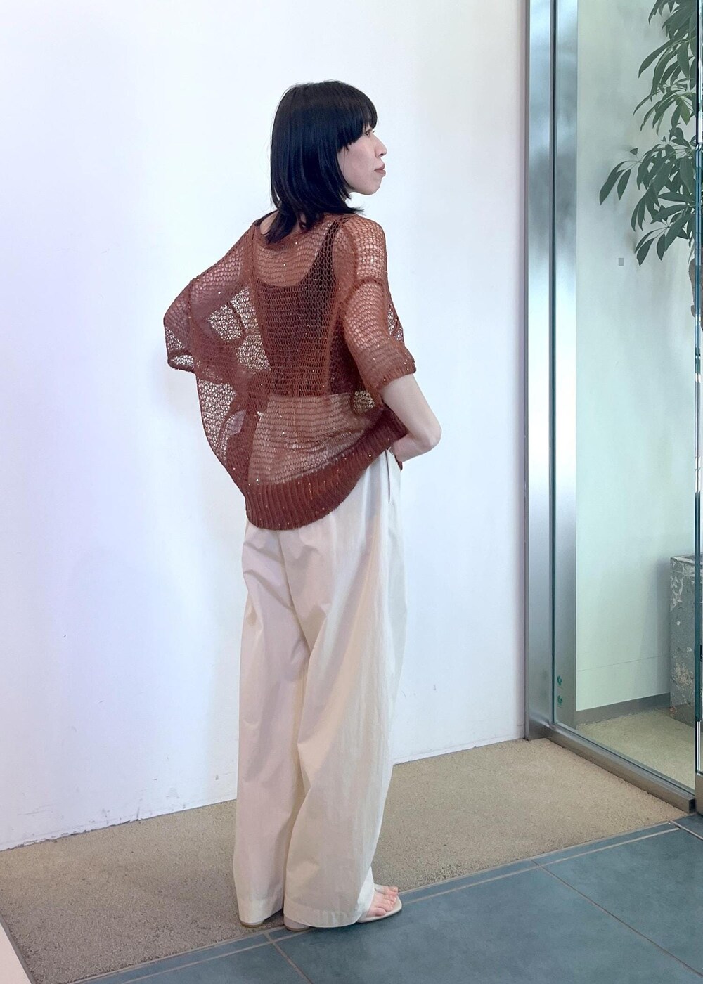 ブラック系のタンクトップ、ホワイト系のその他パンツ、ブラウン系のニット/セーターを着用したレディースの春コーディネートの2枚目の写真