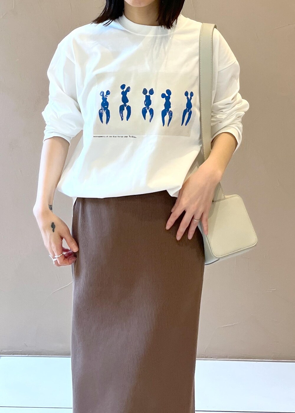 シルバー系のサンダル、ブラウン系のスカート、グレー系のショルダーバッグを着用したレディースの夏コーディネートの5枚目の写真