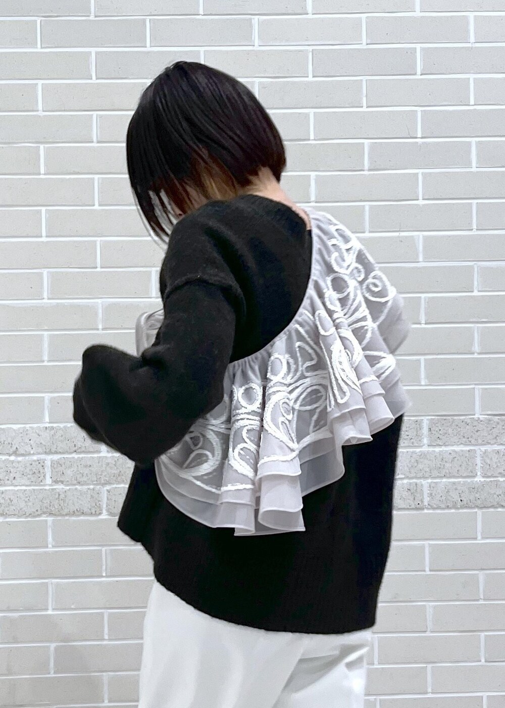 ブラウン系のニット/セーター、ホワイト系のその他パンツ、ベージュ系のストール/ショールを着用したレディースの冬コーディネートの5枚目の写真