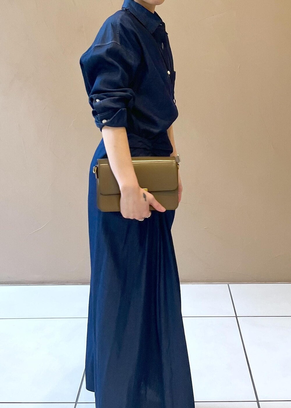 ブラウン系のショルダーバッグ、ベージュ系のパンプス、ブルー系のシャツ/ブラウスを着用したレディースの冬コーディネートの7枚目の写真