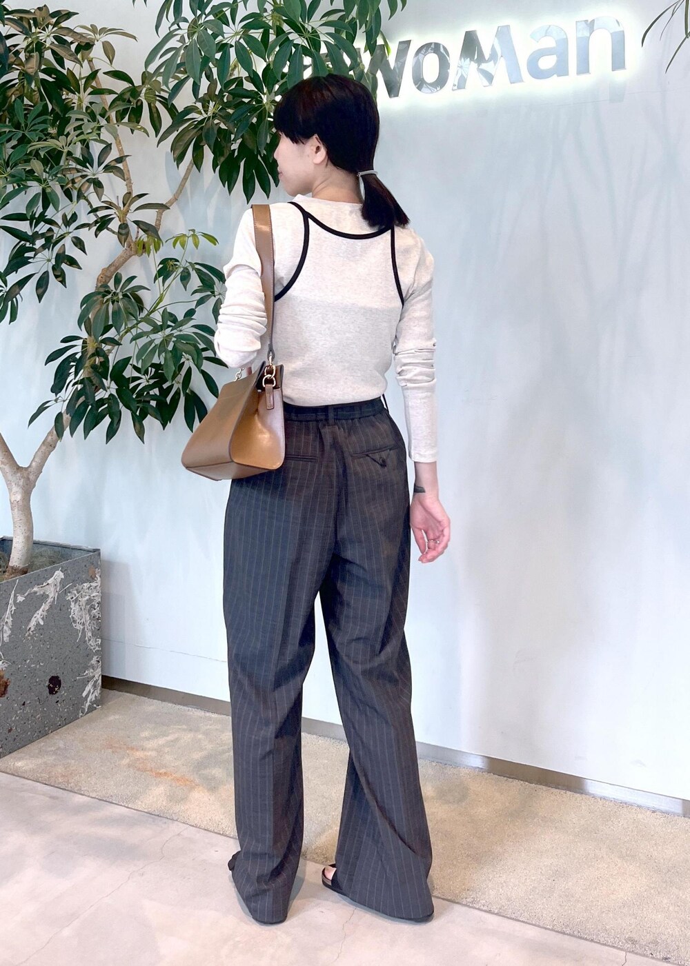 ブラウン系のショルダーバッグ、ベージュ系のタンクトップ、ベージュ系のTシャツ/カットソーを着用したレディースの夏コーディネートの4枚目の写真