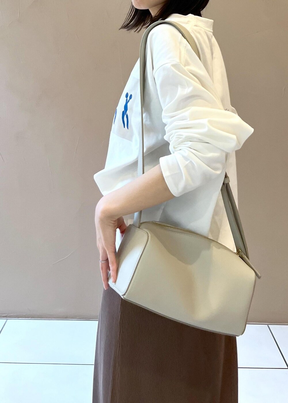 シルバー系のサンダル、ブラウン系のスカート、グレー系のショルダーバッグを着用したレディースの夏コーディネートの6枚目の写真