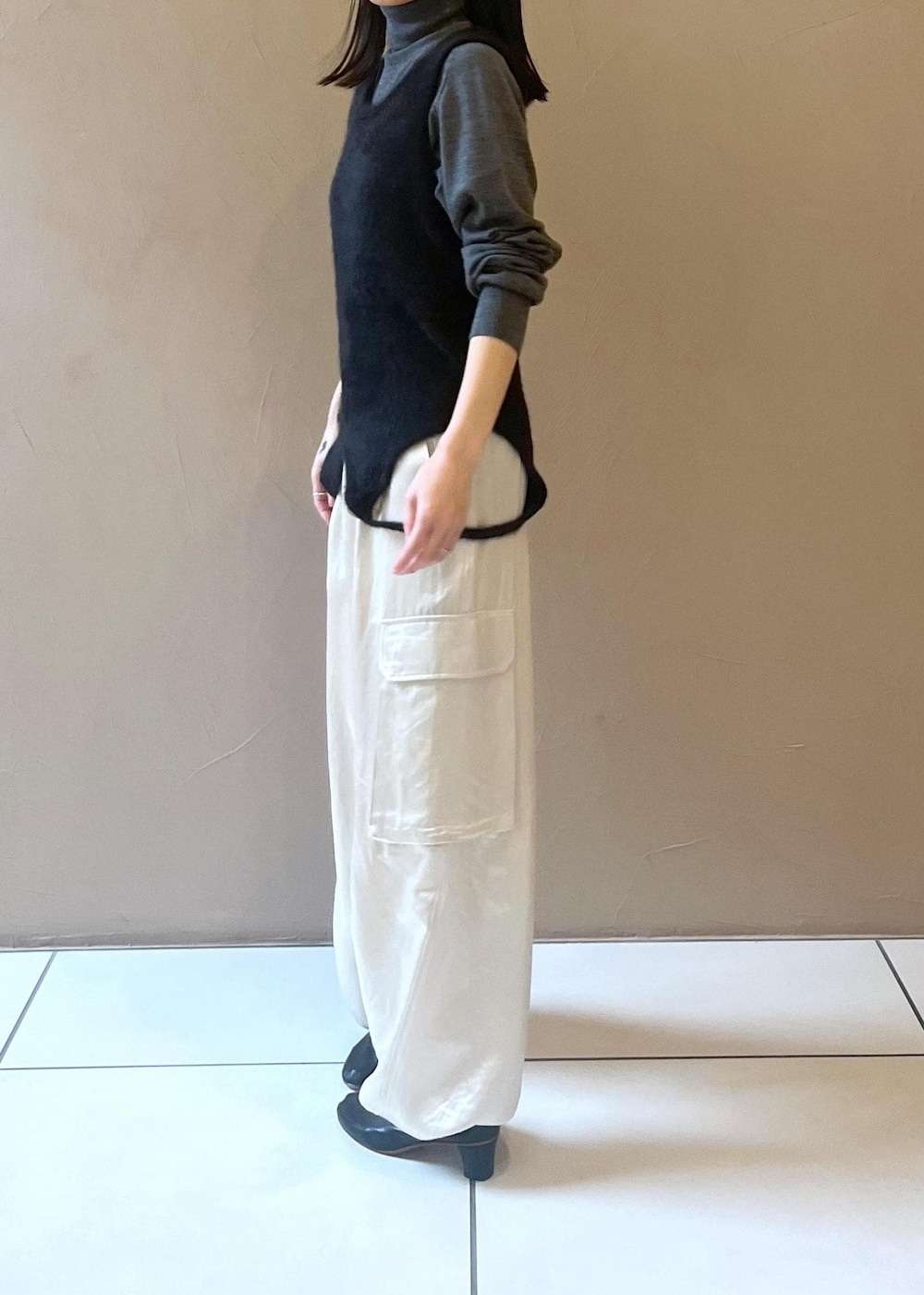 ホワイト系のカーゴパンツ、ブラック系のタンクトップ、グレー系のニット/セーターを着用したレディースの秋コーディネートの7枚目の写真