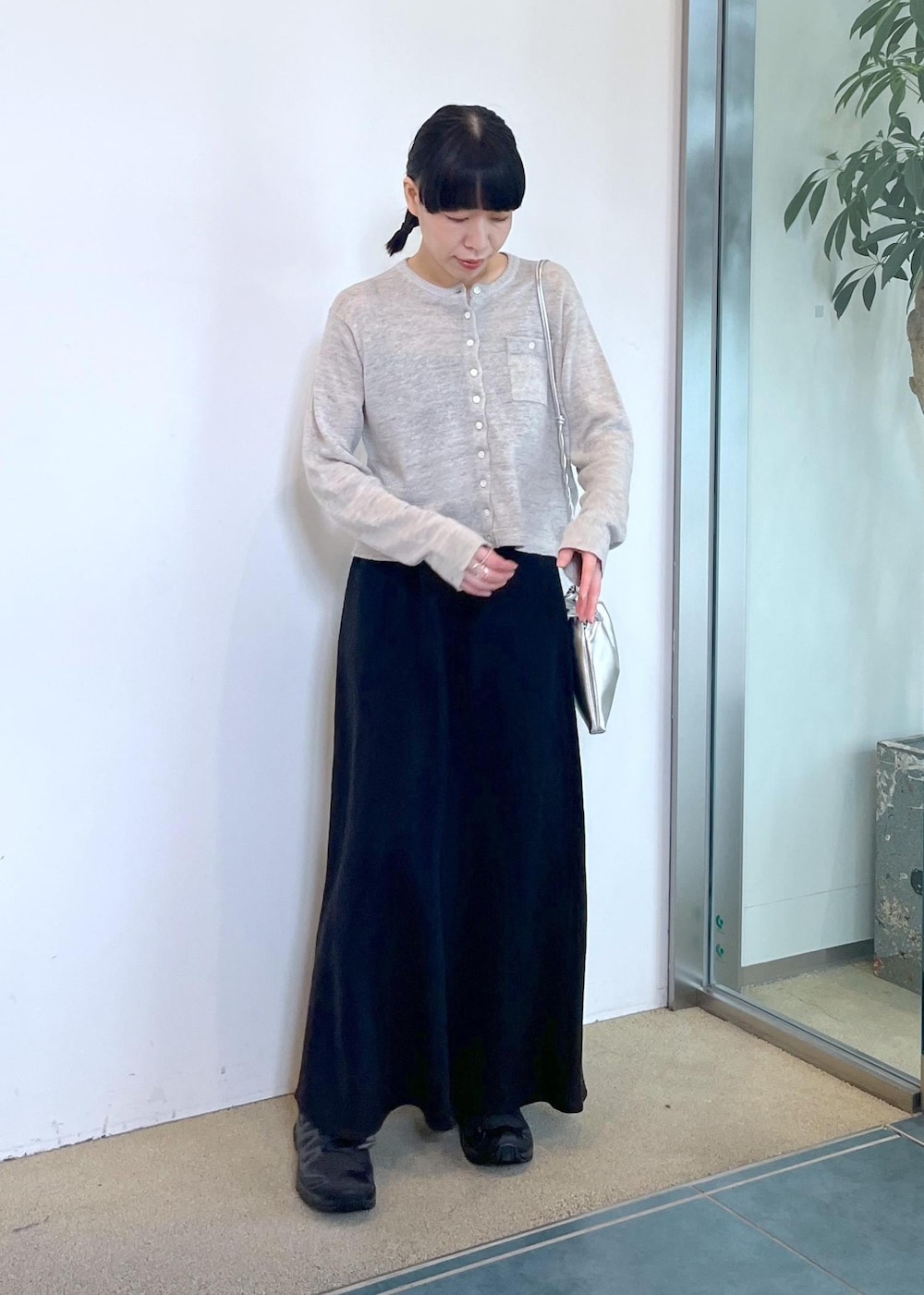 グレー系のカーディガン/ボレロ、ブラック系のスカート、シルバー系のショルダーバッグを着用したレディースの春コーディネートの5枚目の写真