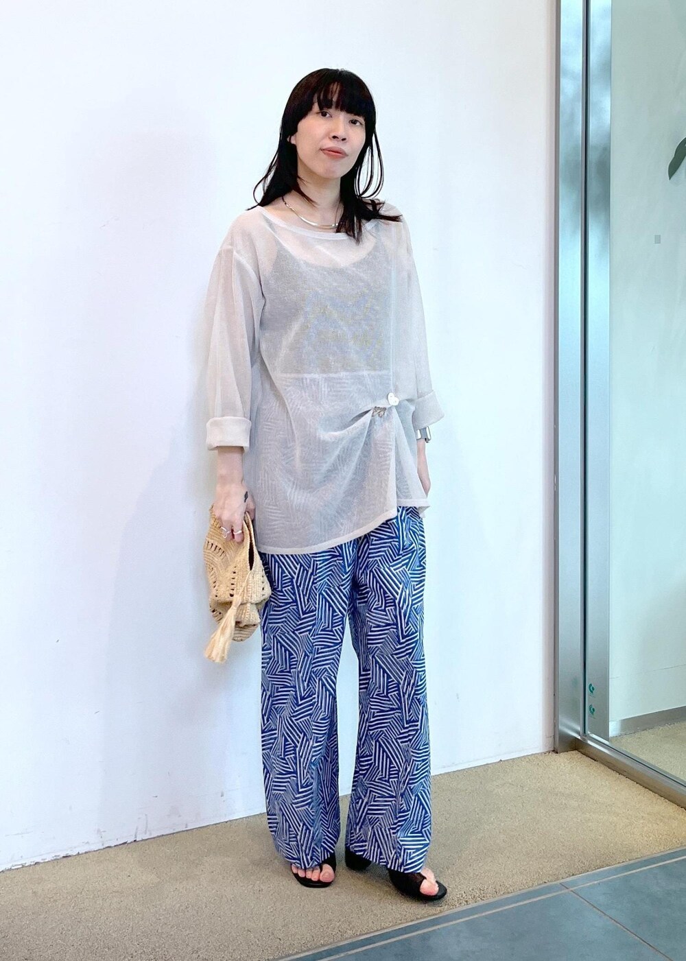 ホワイト系のニット/セーター、ブルー系のその他パンツを着用したレディースの夏コーディネートの2枚目の写真