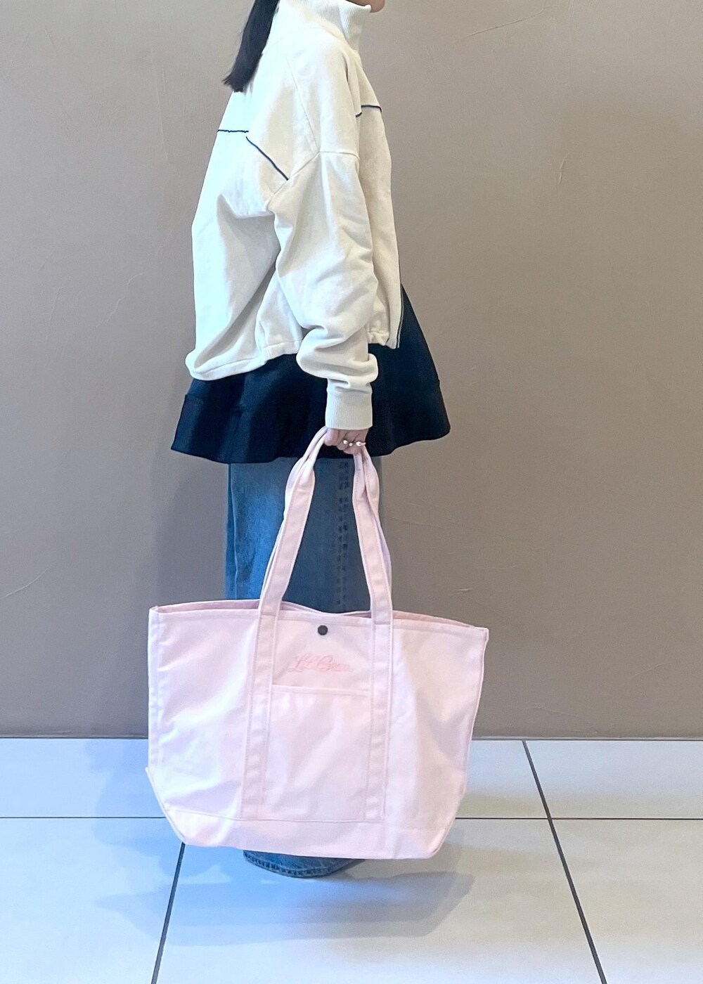 ブルー系のデニムパンツ、ブラック系のスカート、ホワイト系のタンクトップを着用したレディースの冬コーディネートの4枚目の写真