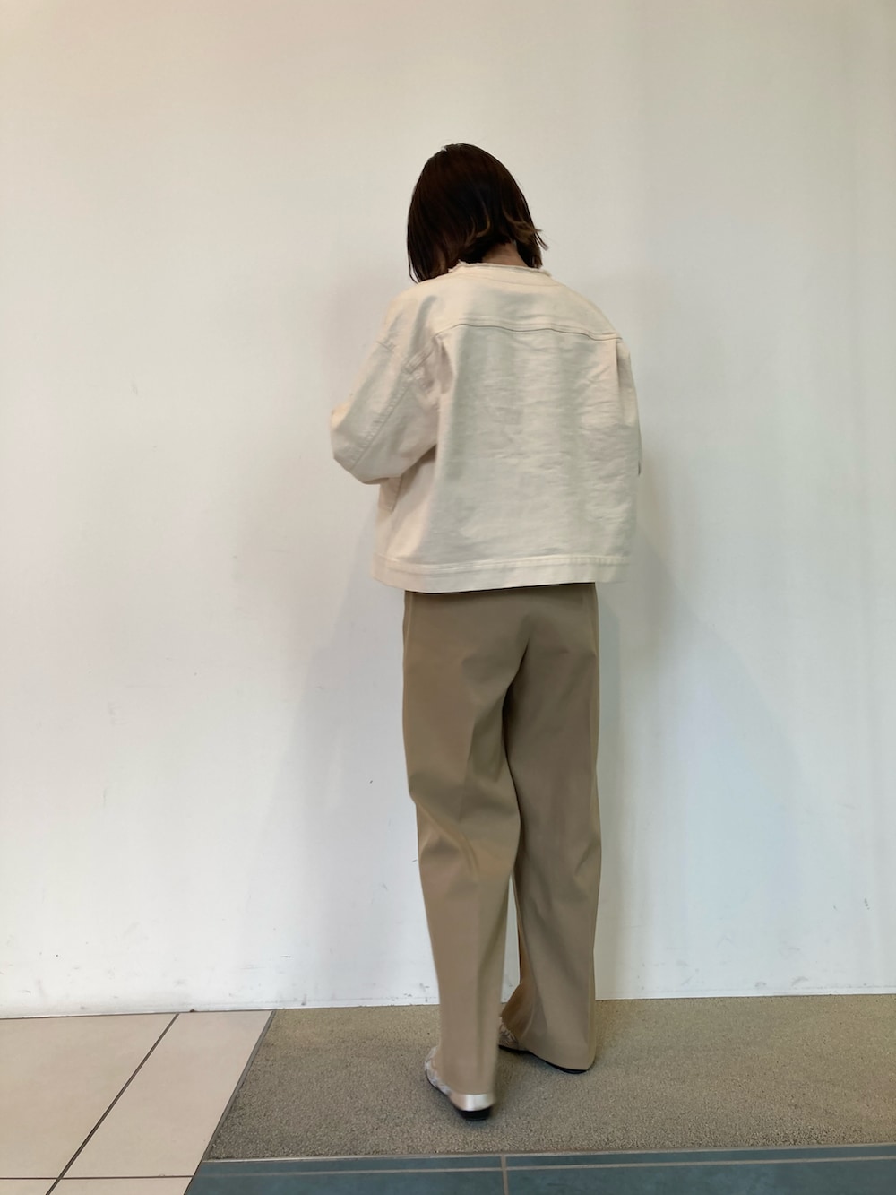 ブラック系のニット/セーター、ホワイト系のブルゾン、ベージュ系のその他パンツを着用したレディースの春コーディネートの3枚目の写真