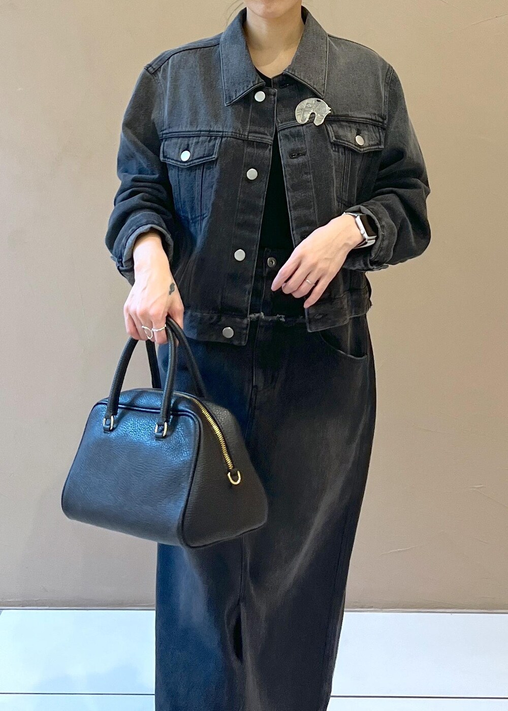 ブラック系のボストンバッグ、グレー系のデニムスカート、グレー系のデニムジャケットを着用したレディースの秋コーディネートの5枚目の写真