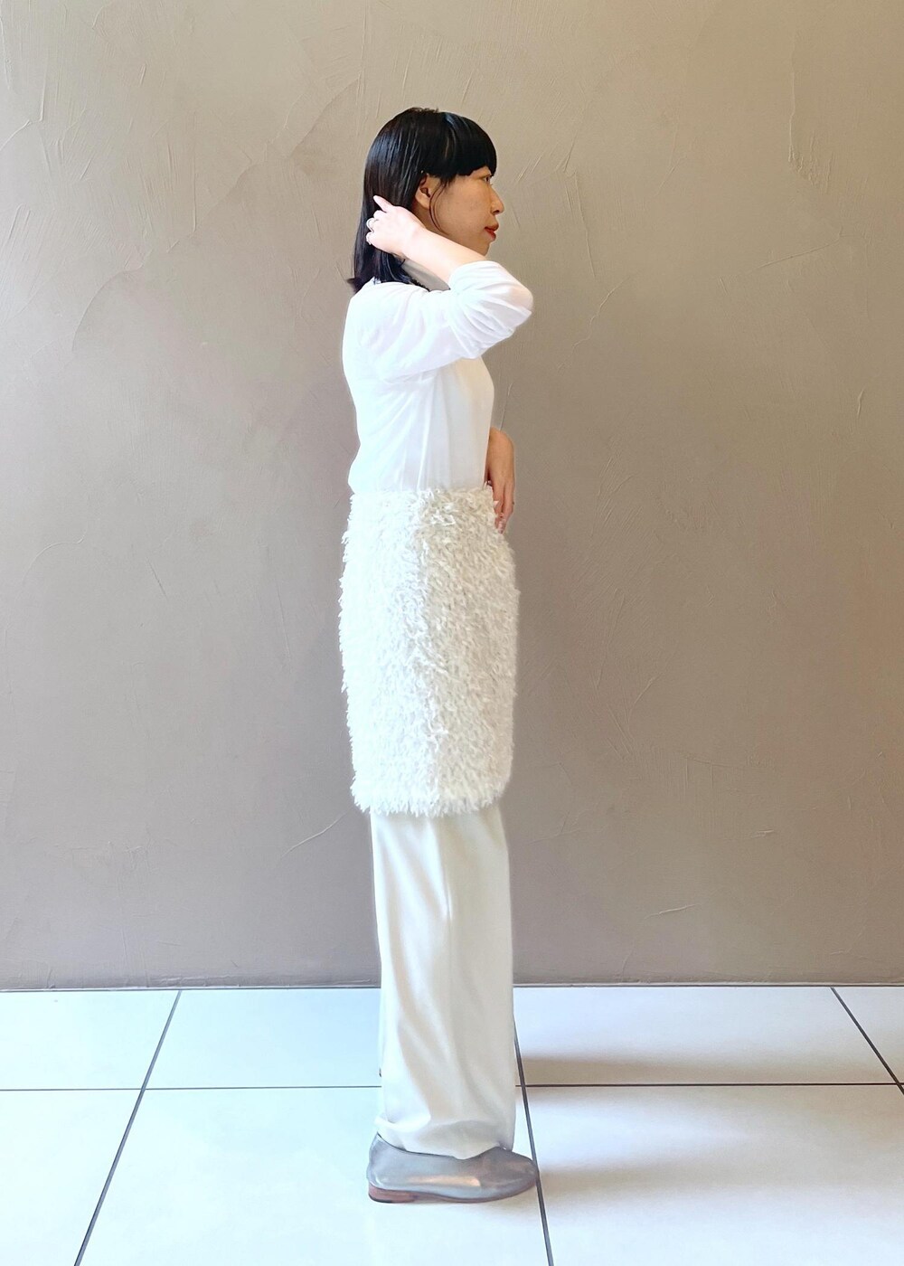 グレー系のショルダーバッグ、ホワイト系のスカート、ベージュ系のその他パンツを着用したレディースの秋コーディネートの4枚目の写真