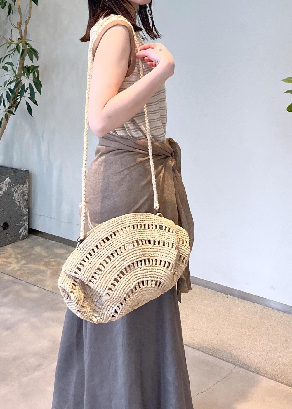 ベージュ系のサンダル、グレー系のスカート、ゴールド系のカーディガン/ボレロを着用したレディースの春コーディネートの6枚目の写真