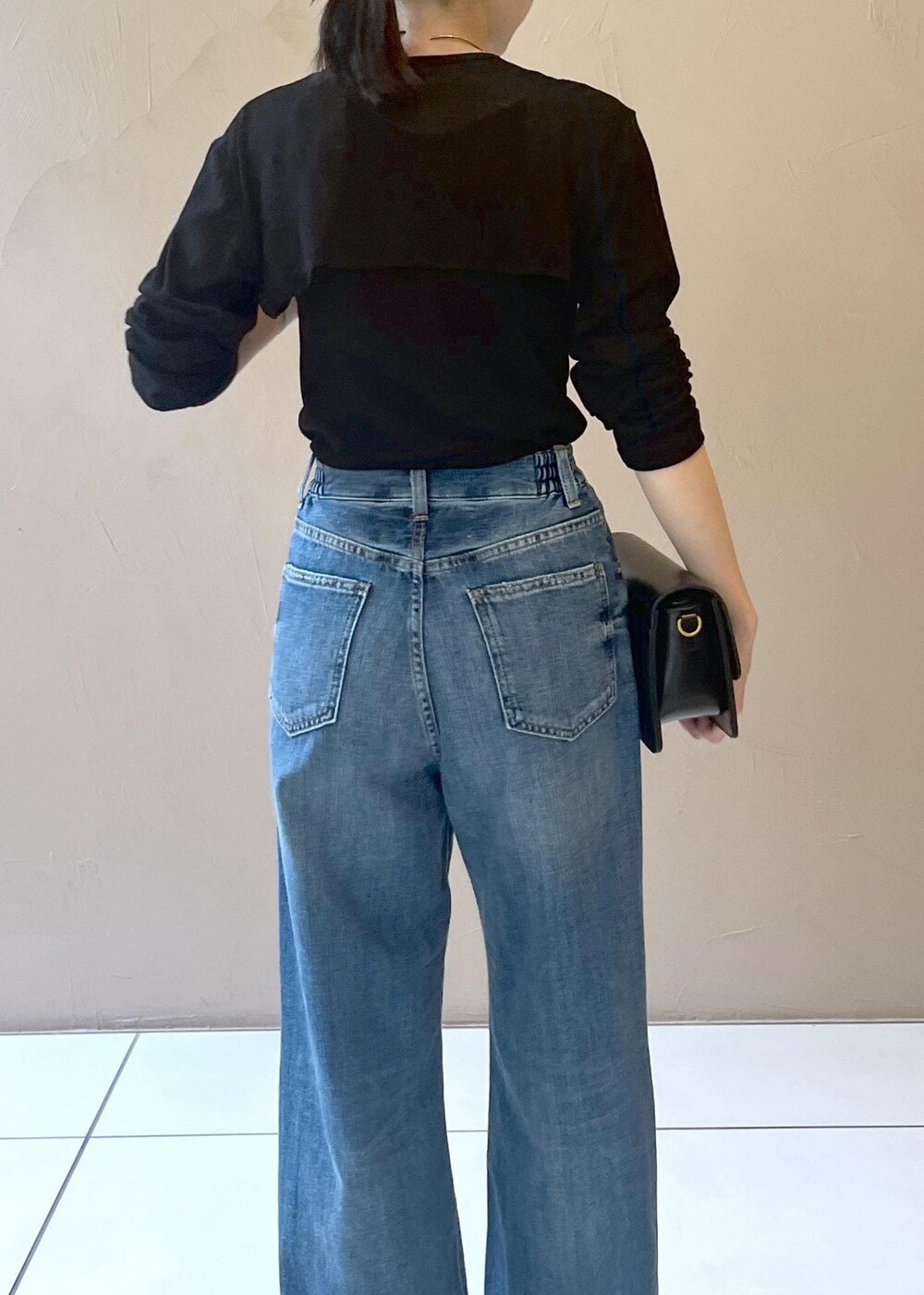 ブルー系のデニムパンツ、ブラック系のショルダーバッグ、ブラック系のカーディガン/ボレロを着用したレディースの夏コーディネートの6枚目の写真