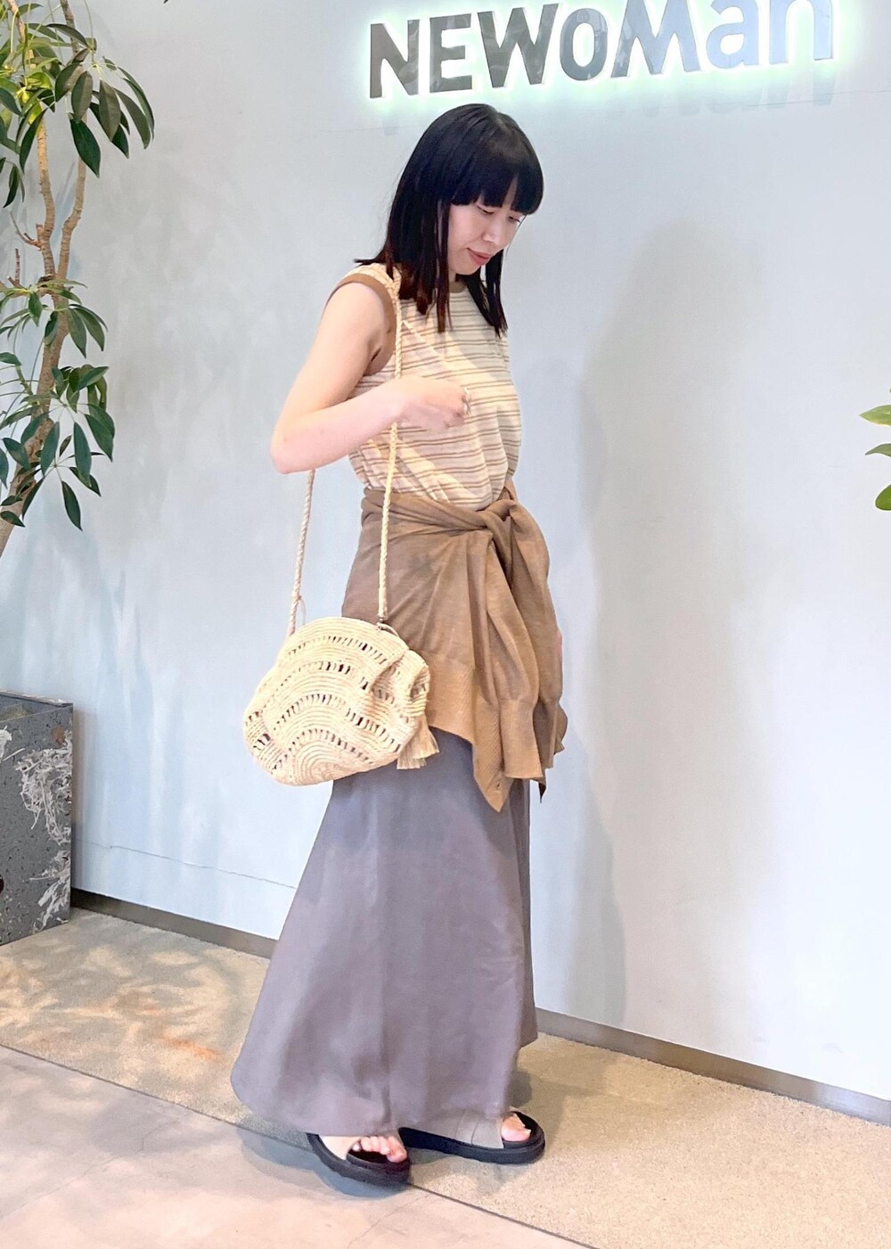 ベージュ系のサンダル、グレー系のスカート、ゴールド系のカーディガン/ボレロを着用したレディースの春コーディネートの3枚目の写真