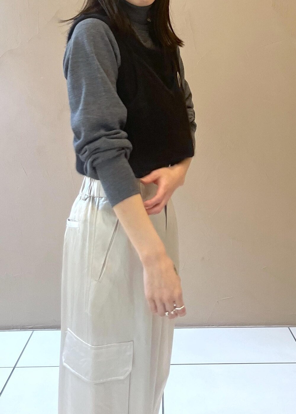 ホワイト系のカーゴパンツ、ブラック系のタンクトップ、グレー系のニット/セーターを着用したレディースの秋コーディネートの6枚目の写真