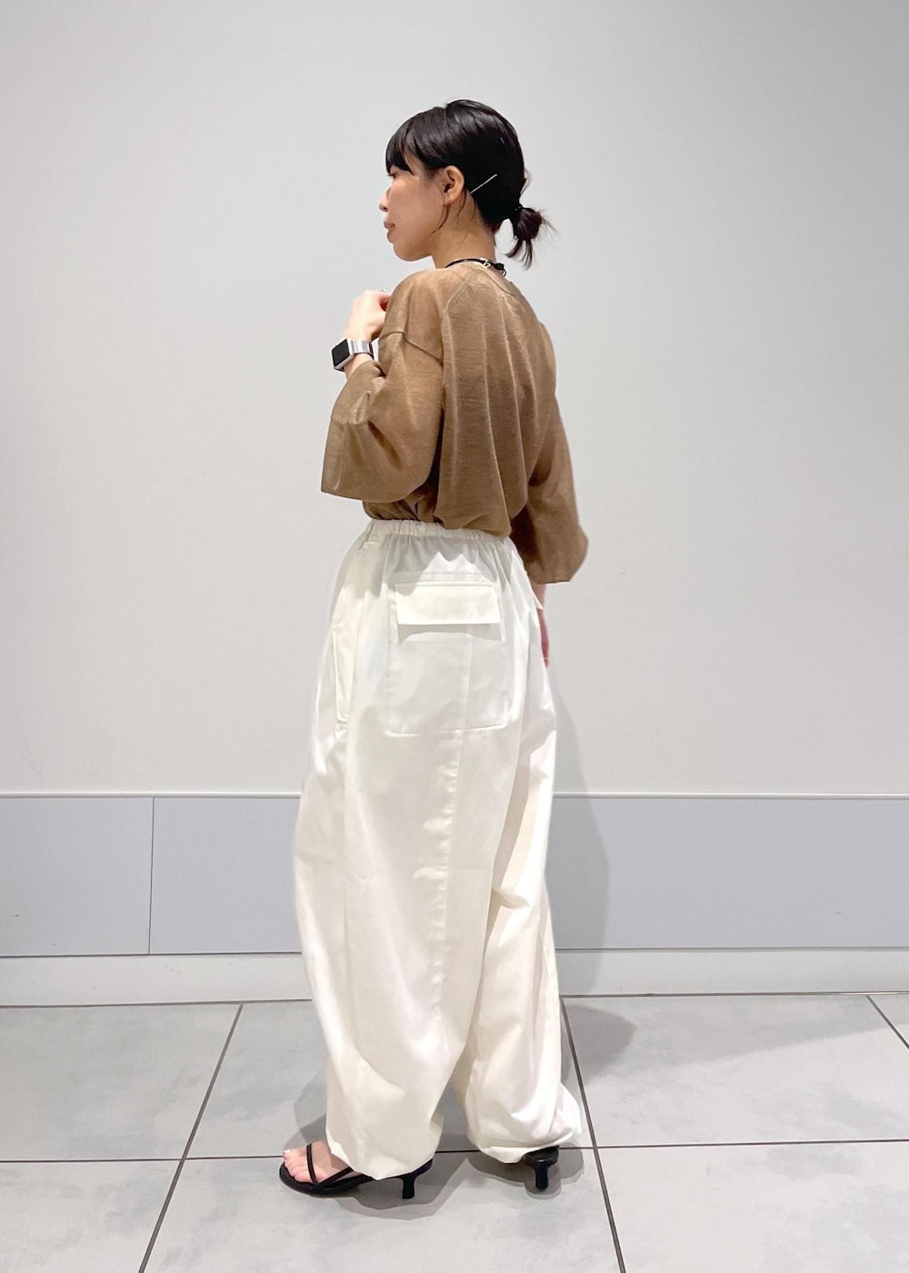 ブラック系のサンダル、ホワイト系のカーゴパンツ、ゴールド系のTシャツ/カットソーを着用したレディースの夏コーディネートの3枚目の写真