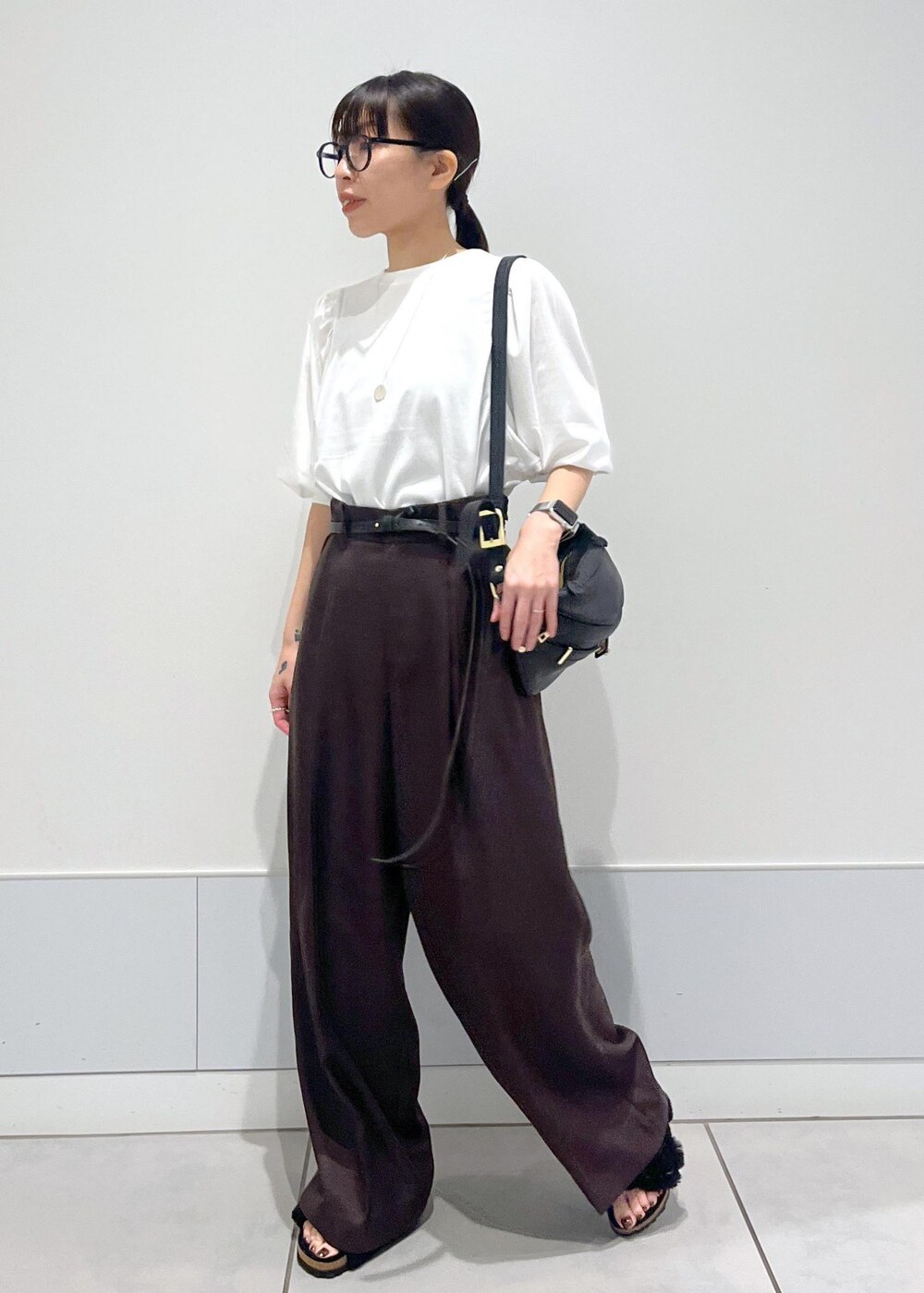 ホワイト系のTシャツ/カットソー、ブラウン系のスラックス、ブラック系のボディバッグ/ウエストポーチを着用したレディースの秋コーディネートの3枚目の写真