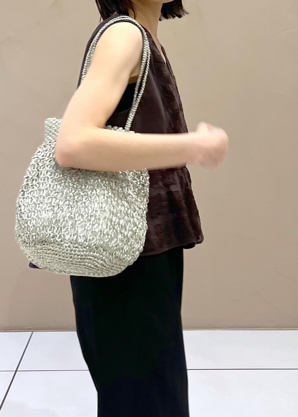 ブラック系のスラックス、シルバー系のサンダルを着用したレディースの夏コーディネートの5枚目の写真