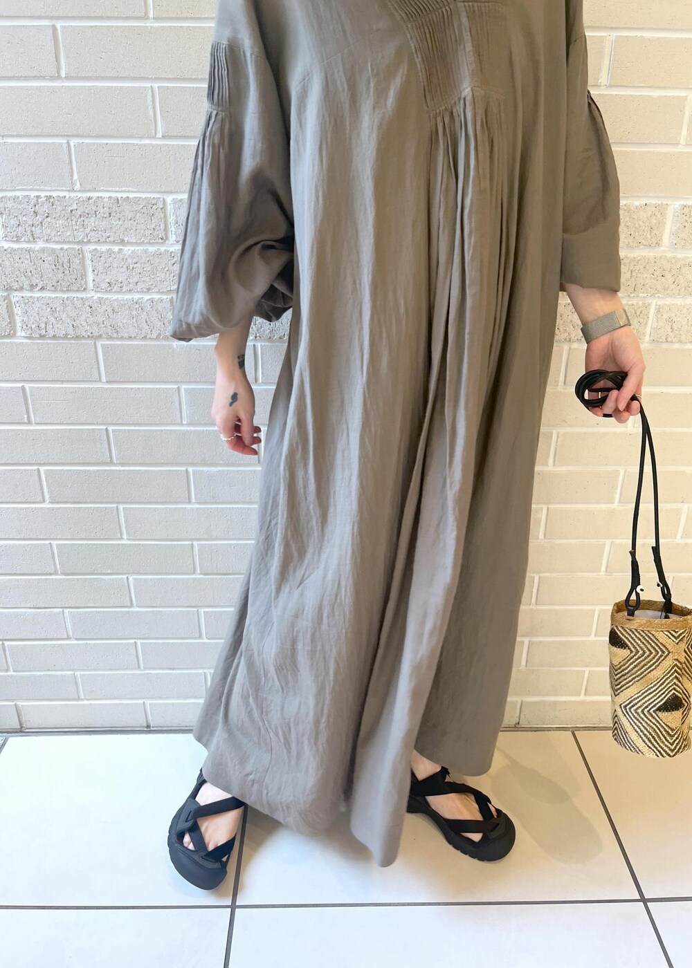 グレー系のワンピースを着用したレディースの夏コーディネートの5枚目の写真