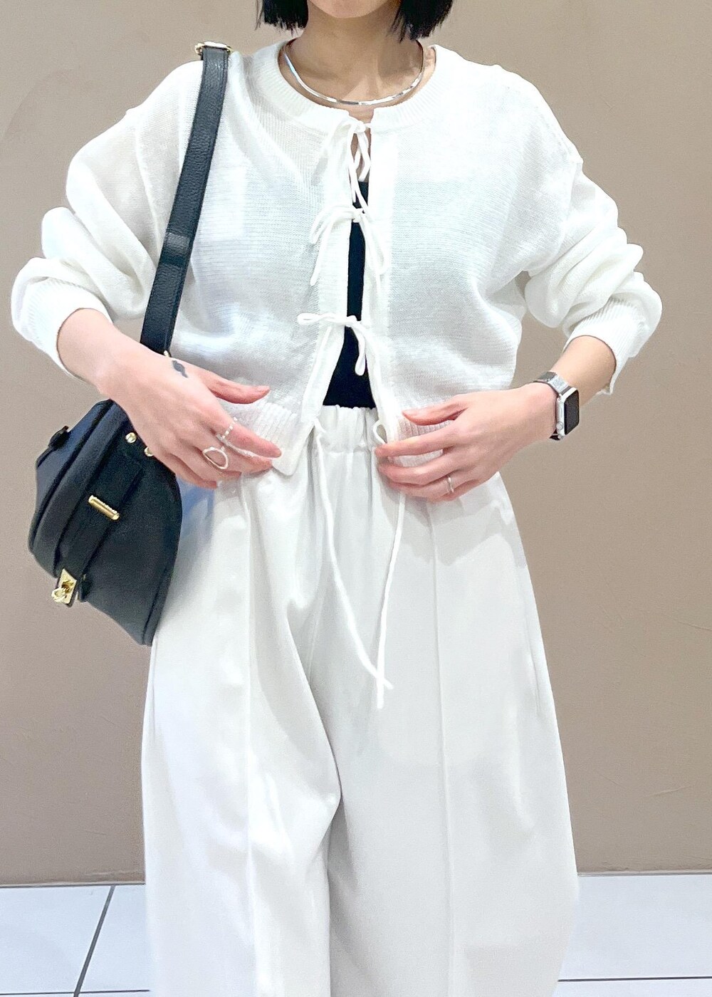 ホワイト系のニット/セーター、ブラック系のボディバッグ/ウエストポーチを着用したレディースの春コーディネートの5枚目の写真