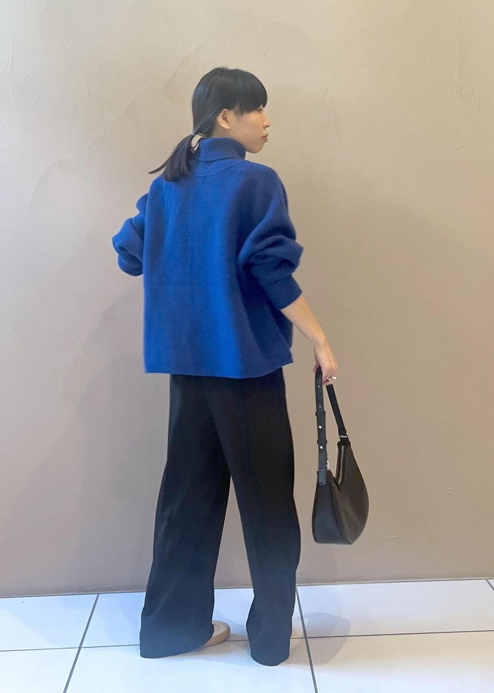 ホワイト系のスニーカー、ブルー系のカーディガン/ボレロ、ブラック系のその他パンツを着用したレディースの秋コーディネートの3枚目の写真