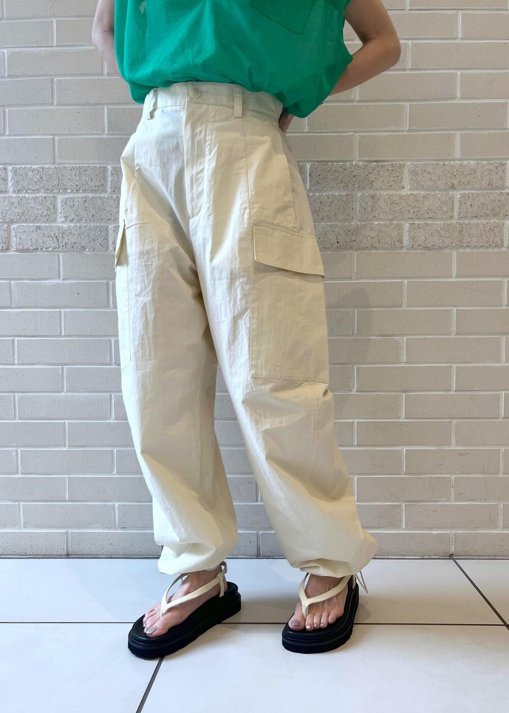 ホワイト系のカーゴパンツ、ホワイト系のチューブトップ、ブラック系のハンドバッグを着用したレディースの春コーディネートの4枚目の写真