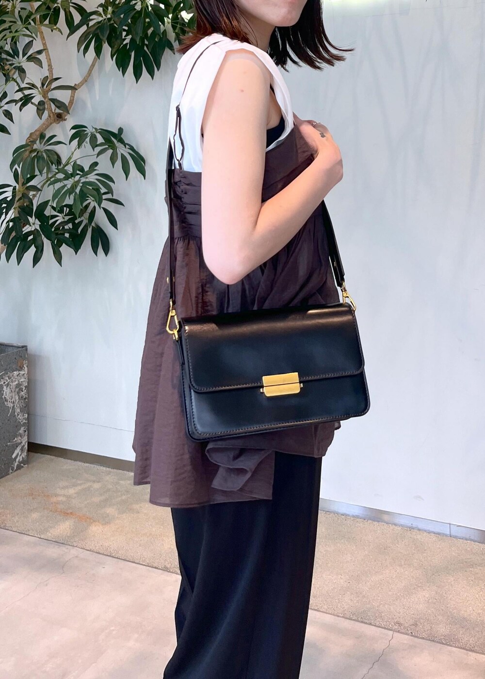 ホワイト系のTシャツ/カットソー、ブラウン系のキャミソール、ブラック系のショルダーバッグを着用したレディースの夏コーディネートの6枚目の写真