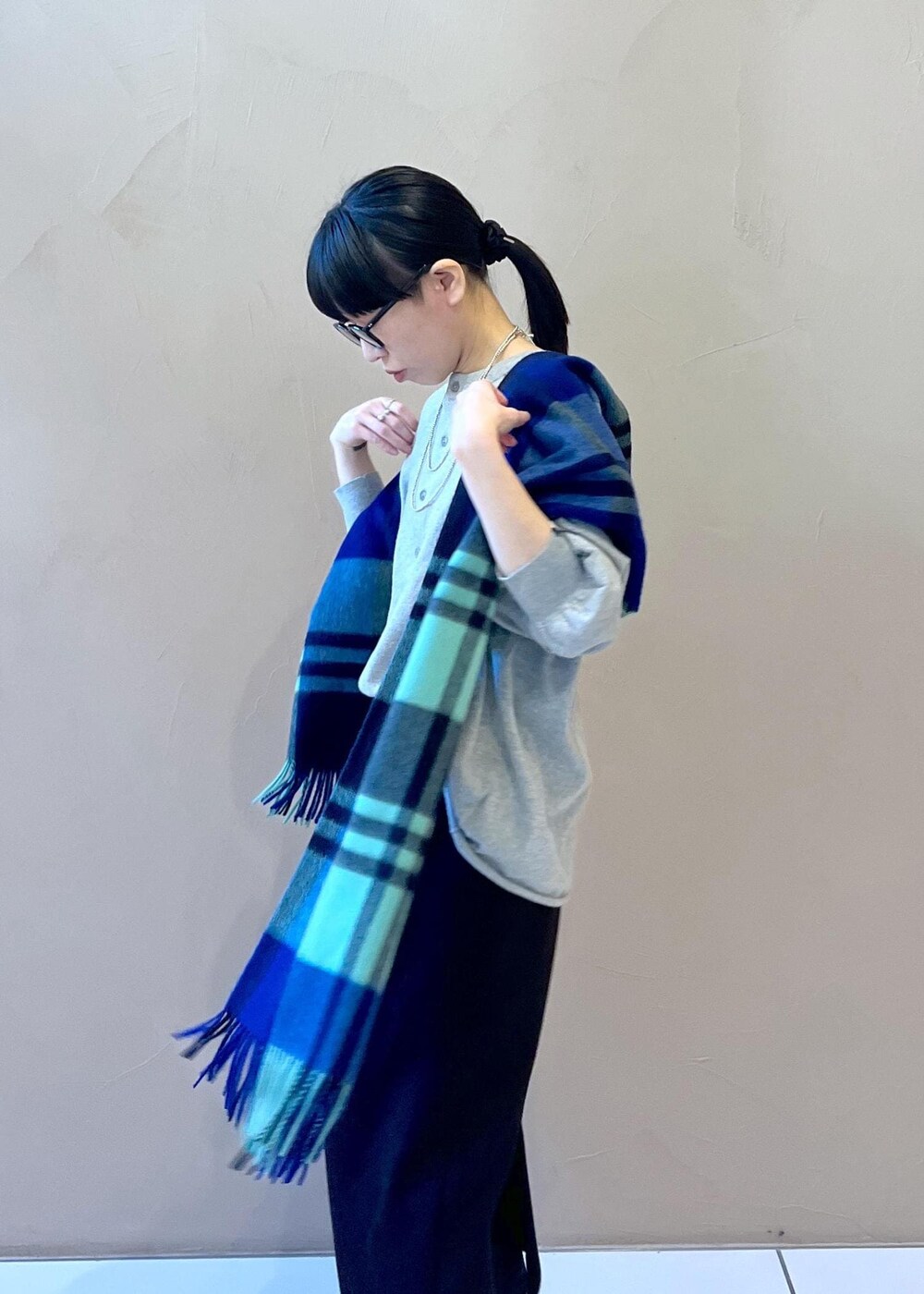 ブラック系のスカート、ブラック系のブーツ、グリーン系のストール/ショールを着用したレディースの冬コーディネートの9枚目の写真