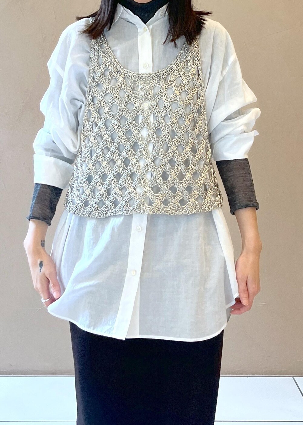 ブラック系のスカート、シルバー系のベスト、ホワイト系のシャツ/ブラウスを着用したレディースの秋コーディネートの4枚目の写真