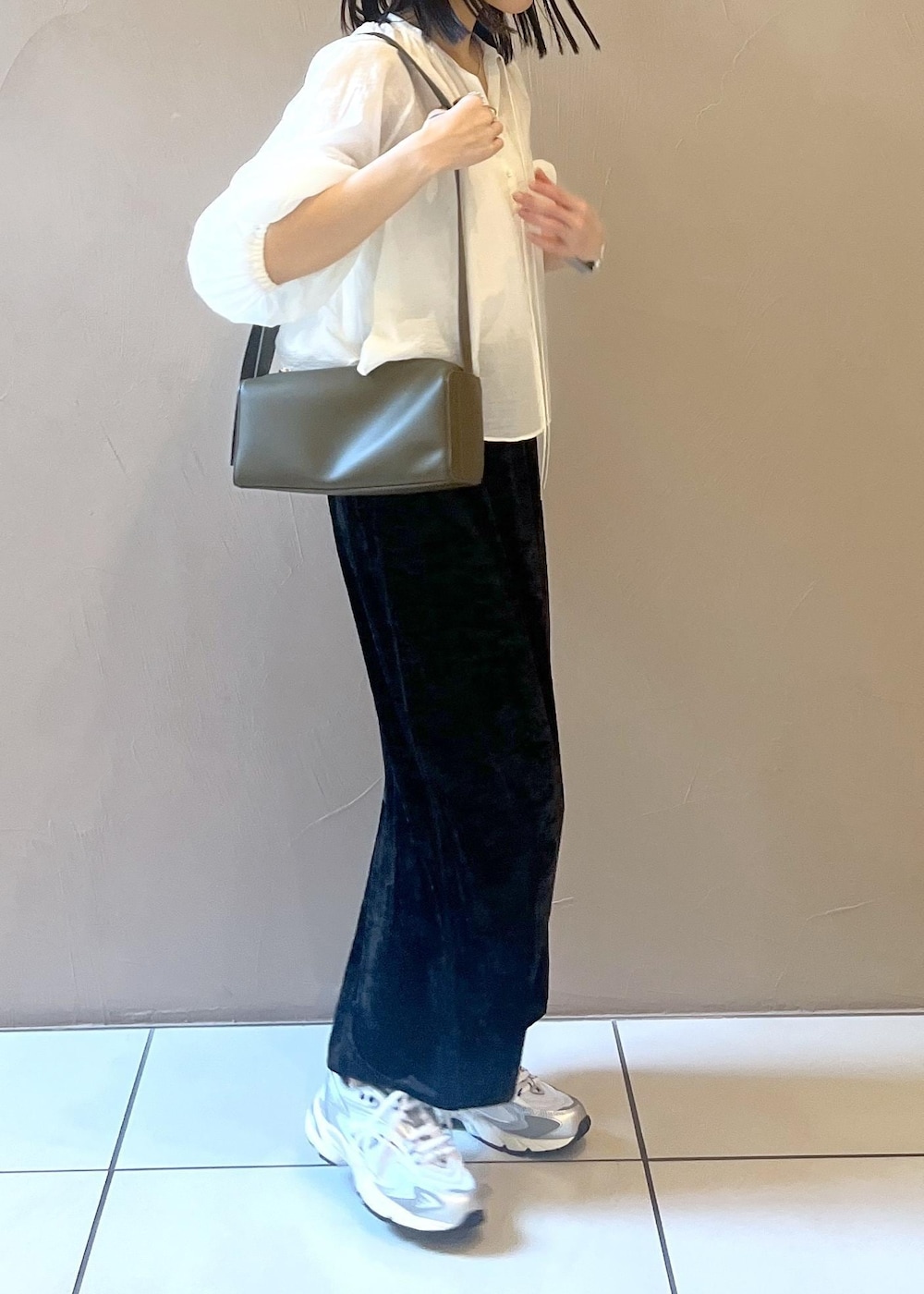 ブラック系のスカート、グリーン系のショルダーバッグ、ホワイト系のシャツ/ブラウスを着用したレディースの夏コーディネートの3枚目の写真