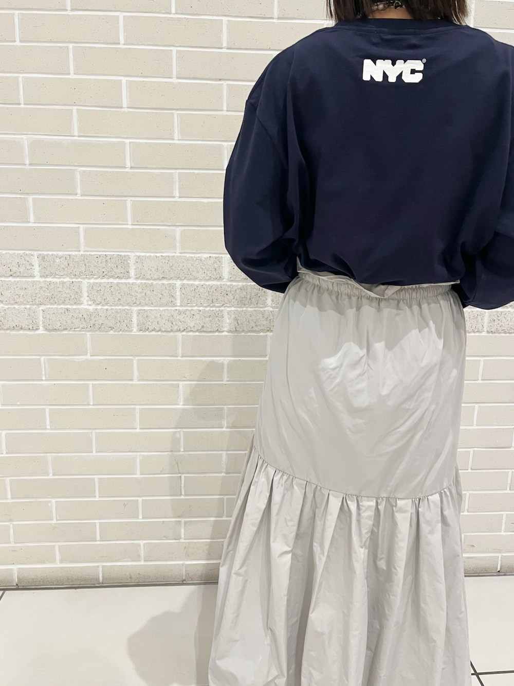 ブルー系のTシャツ/カットソー、グレー系のスカート、グリーン系のスニーカーを着用したレディースの冬コーディネートの2枚目の写真
