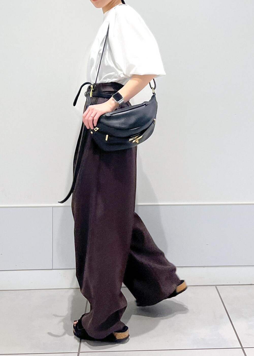 ホワイト系のTシャツ/カットソー、ブラウン系のスラックス、ブラック系のボディバッグ/ウエストポーチを着用したレディースの秋コーディネートの4枚目の写真