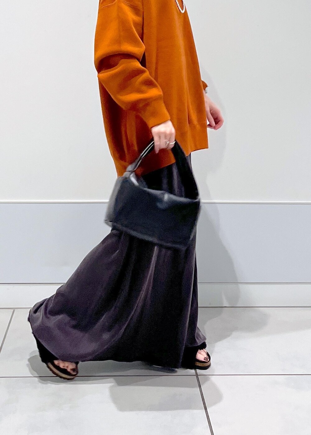 ブラック系のハンドバッグ、ブラック系のサンダル、レッド系のスウェットを着用したレディースの夏コーディネートの4枚目の写真