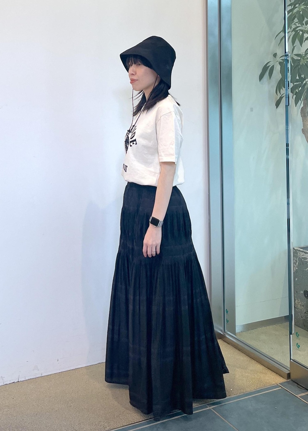 ブラック系のサンダル、ホワイト系のTシャツ/カットソー、ブラック系のスカートを着用したレディースの夏コーディネートの3枚目の写真