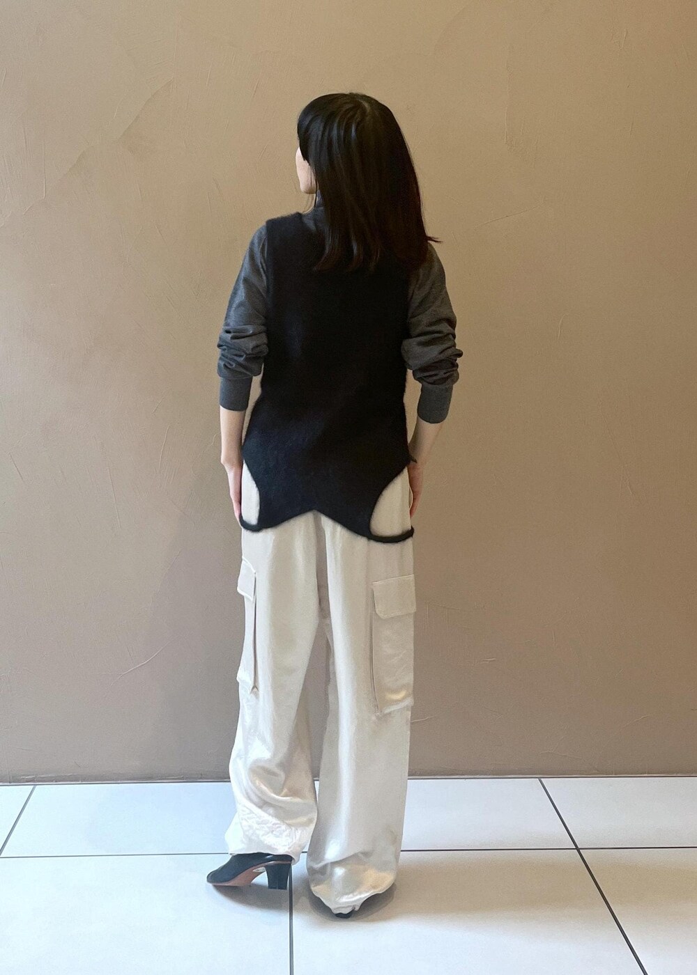ホワイト系のカーゴパンツ、ブラック系のタンクトップ、グレー系のニット/セーターを着用したレディースの秋コーディネートの9枚目の写真