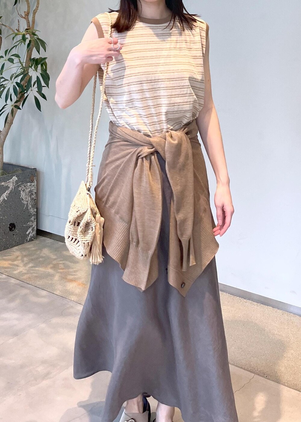 ベージュ系のサンダル、グレー系のスカート、ゴールド系のカーディガン/ボレロを着用したレディースの春コーディネートの5枚目の写真