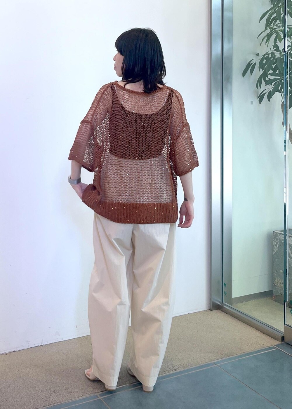 ブラック系のタンクトップ、ホワイト系のその他パンツ、ブラウン系のニット/セーターを着用したレディースの春コーディネートの3枚目の写真