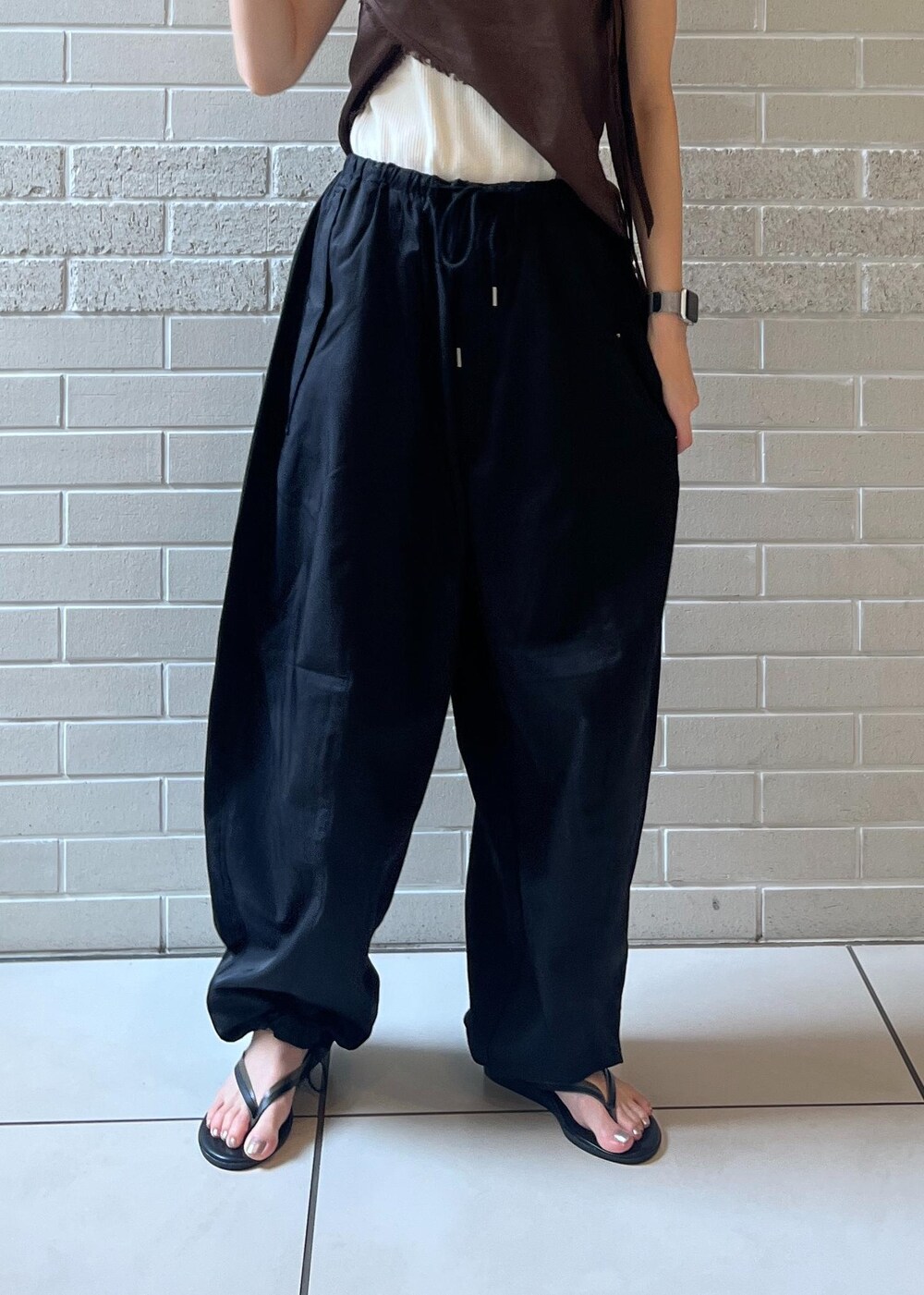 ホワイト系のタンクトップ、ブラック系のサンダル、ブラック系のカーゴパンツを着用したレディースの夏コーディネートの5枚目の写真