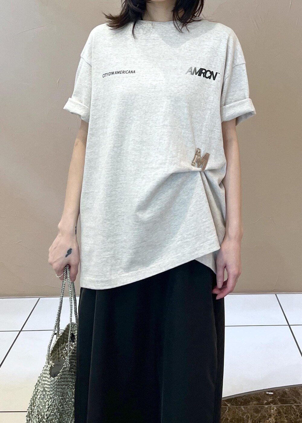 ブラック系のワンピース、ホワイト系のTシャツ/カットソー、シルバー系のトートバッグを着用したレディースの春コーディネートの5枚目の写真