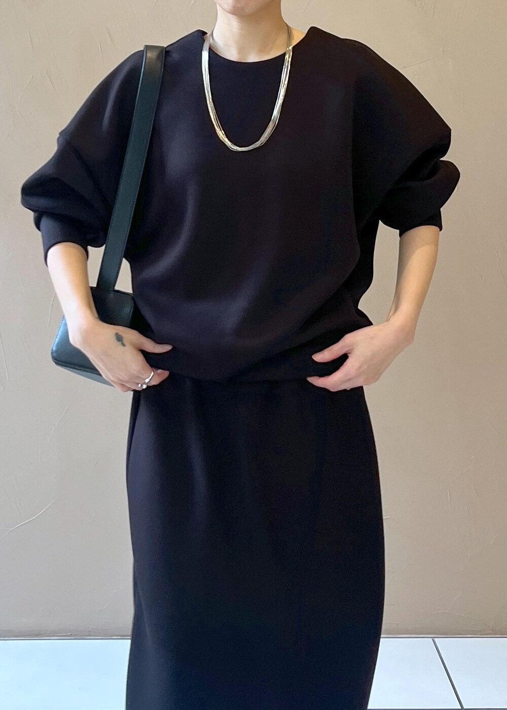 ブラック系のショルダーバッグ、ブラック系のスカート、ブラック系のTシャツ/カットソーを着用したレディースの秋コーディネートの6枚目の写真