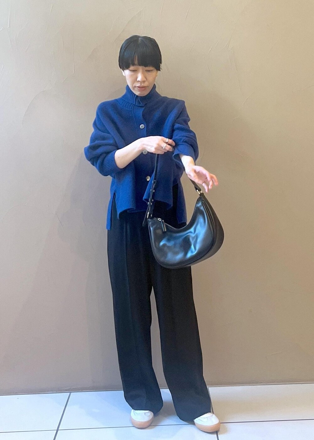 ホワイト系のスニーカー、ブルー系のカーディガン/ボレロ、ブラック系のその他パンツを着用したレディースの秋コーディネートの2枚目の写真