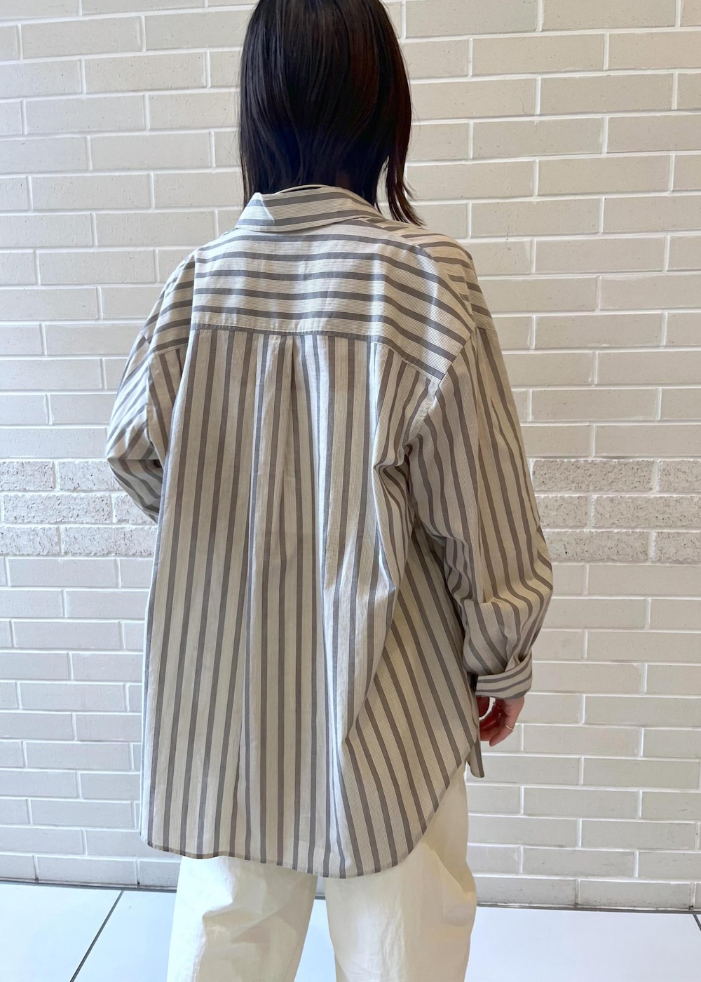 ホワイト系のカーゴパンツ、ブラウン系のサンダル、ホワイト系のチューブトップを着用したレディースの夏コーディネートの4枚目の写真