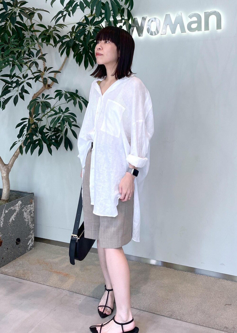 ベージュ系のその他パンツ、ブラック系のサンダル、ホワイト系のシャツ/ブラウスを着用したレディースの夏コーディネートの3枚目の写真